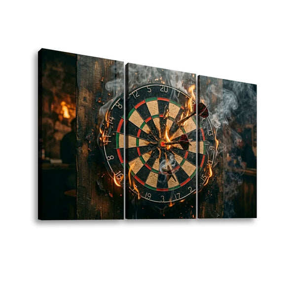 Three-panel canvas wall art showing a dartboard with flaming darts and smoke against a dark rustic background, displayed on a light gray wall.