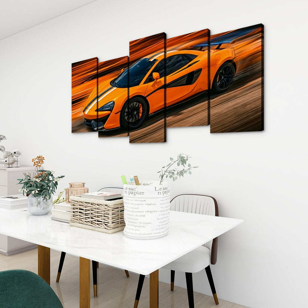A multi-panel canvas wall art set depicting a bright orange sports car in motion, displayed above a white dining table in a modern, sunlit room.