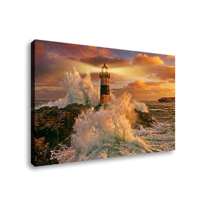 A rectangular canvas wall art print showing a coastal lighthouse surrounded by crashing waves at sunset, photographed against a plain white background.