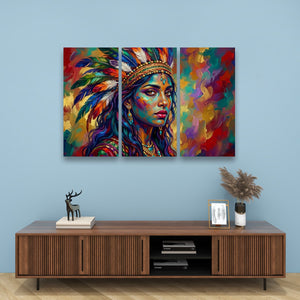 A three-panel canvas wall art set depicting a colorful, textured portrait of a Native American woman with a feathered headdress, displayed on a light blue wall above a wooden console table with decorative items.