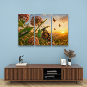 A three-panel canvas wall art set depicting a butterfly and floral landscape at sunset, displayed on a light blue wall above a wooden console table with decorative items.