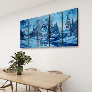 A four-panel canvas wall art set depicting a snowy mountain landscape with blue water and evergreen trees, displayed on a white wall above a light wood dining table with chairs and a green plant.