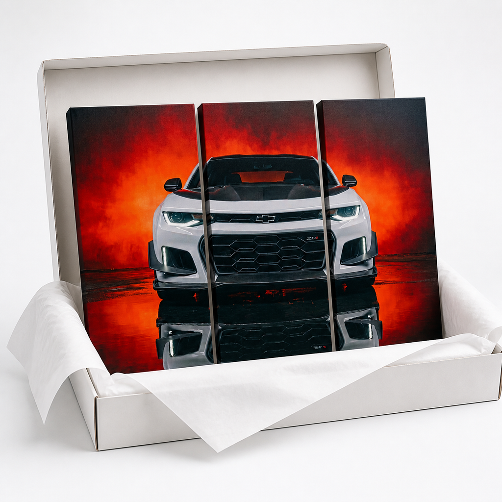 A three-panel canvas wall art print depicting a white Camaro  sports car against a fiery red and orange background, displayed inside an open white gift box with tissue paper on a white background.