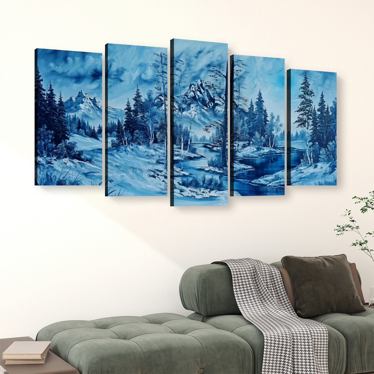 A five-panel canvas wall art set depicting a snowy mountain landscape with pine trees and blue water, displayed above a green sofa in a living room setting.