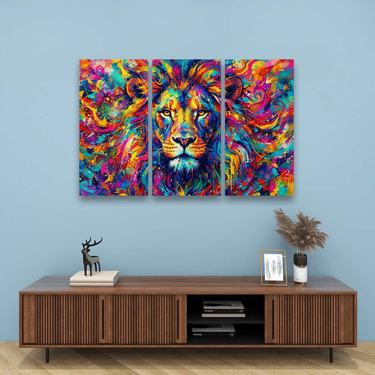 A three-panel canvas wall art set depicting a colorful, vibrant painted lion head, displayed on a light blue wall above a wooden console table with decorative items.