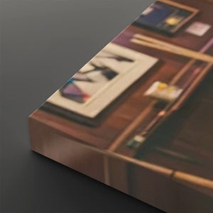 A rectangular box or package photographed at an angle on a dark gray background. The top surface shows a printed scene with a wooden desk, framed artwork, and a pen holder, rendered in soft focus.
