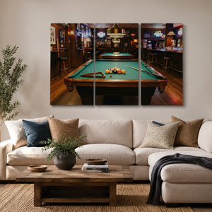 A three-panel canvas wall art print depicting a pool table in a dimly lit bar, displayed above a beige sectional sofa in a modern living room setting.