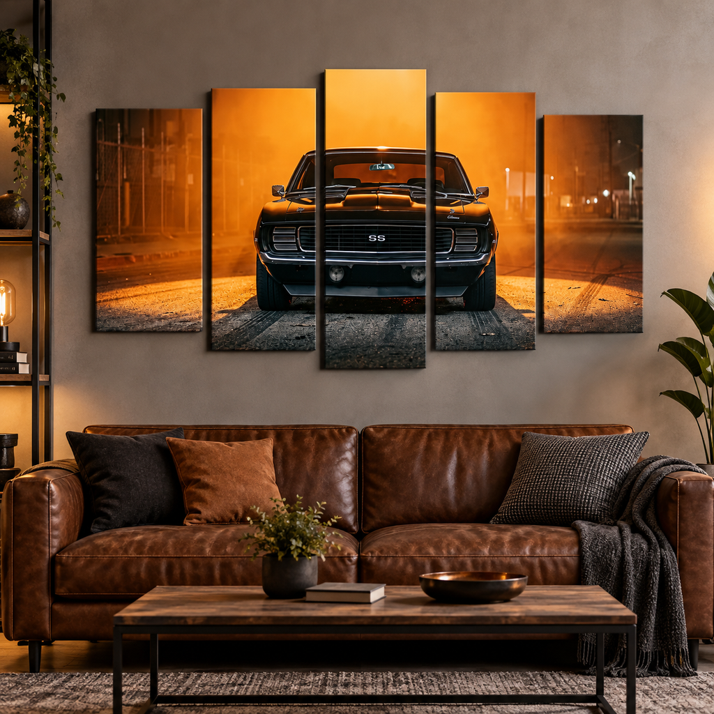 A 5-panel canvas wall art set depicting a black 1969 RS/SS Chevy Camaro muscle car on an orange-lit road at night, displayed above a brown leather sofa in a modern living room setting.