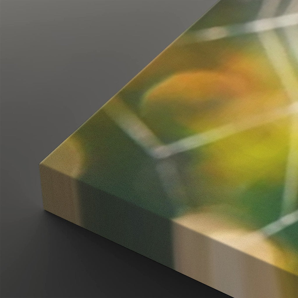 A close-up of a square canvas or panel with an abstract printed design in green, yellow, and orange tones, shown at an angle on a dark gray background.