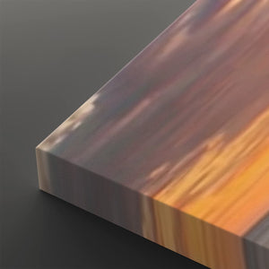 A close-up of a rectangular block or panel with a marbled, wood-like surface in warm brown, orange, and gray tones, shown on a dark gray background.
