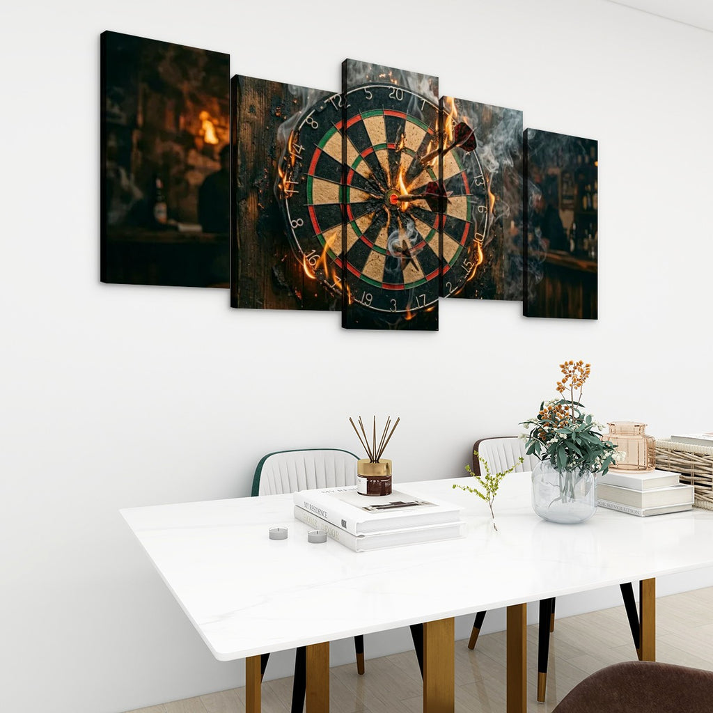 A 5-panel canvas wall art set depicting a burning dartboard in a dimly lit bar, displayed on a white wall above a modern dining table with chairs and decorative items.
