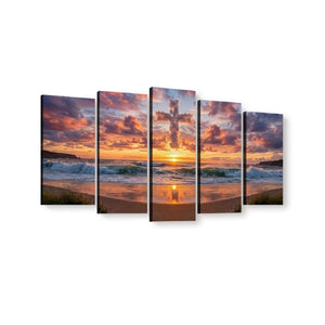 A five-panel canvas wall art set depicting a beach sunset with dramatic clouds, ocean waves, and a cross reflection in the water, shown against a plain white background.