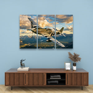 A three-panel canvas wall art print depicting a vintage military airplane flying over mountains under a dramatic cloudy sky, displayed above a wooden console table in a styled room setting.