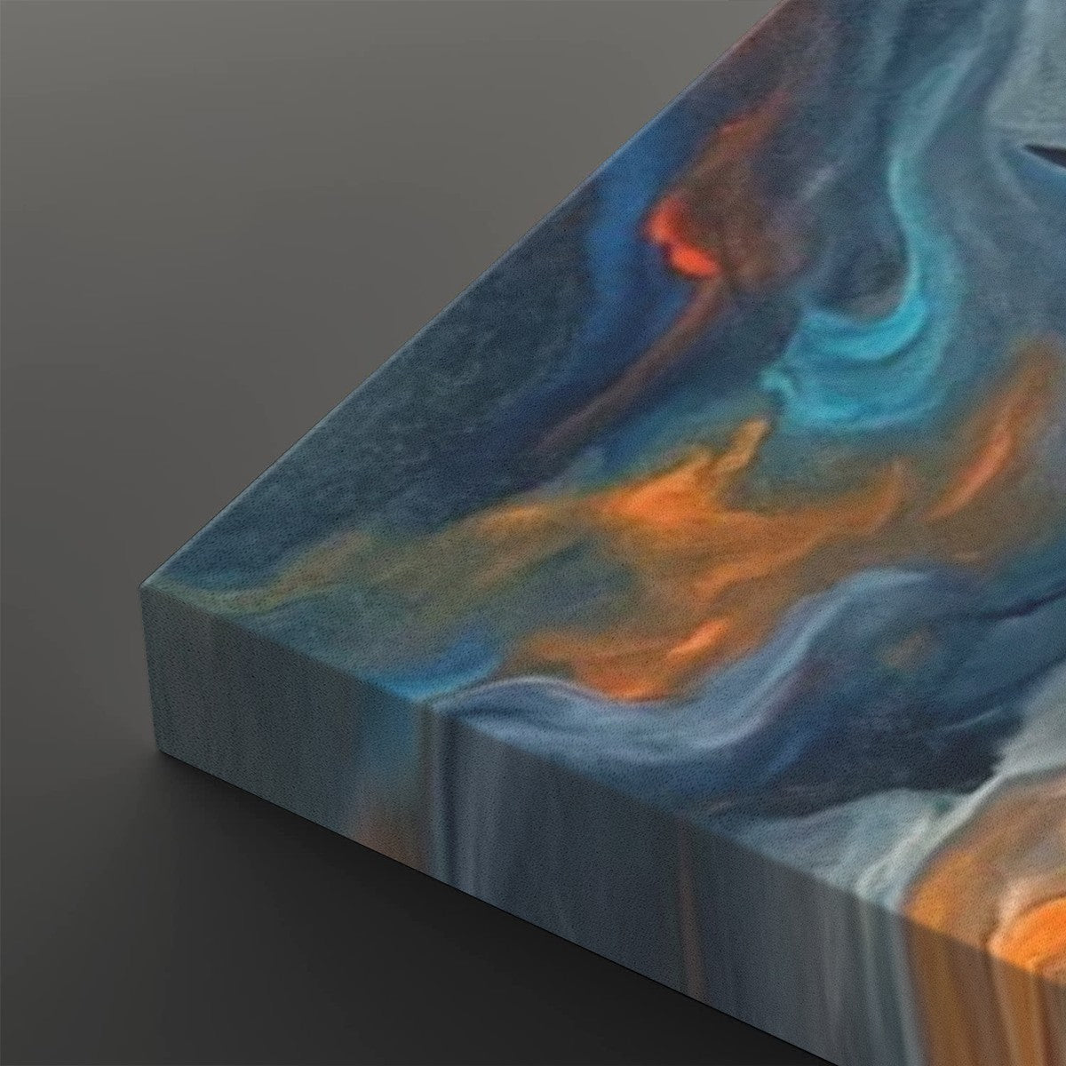 Abstract canvas wall art showing a marbled fluid design with swirling blue, teal, orange, and white tones, photographed at an angle against a dark gray background.