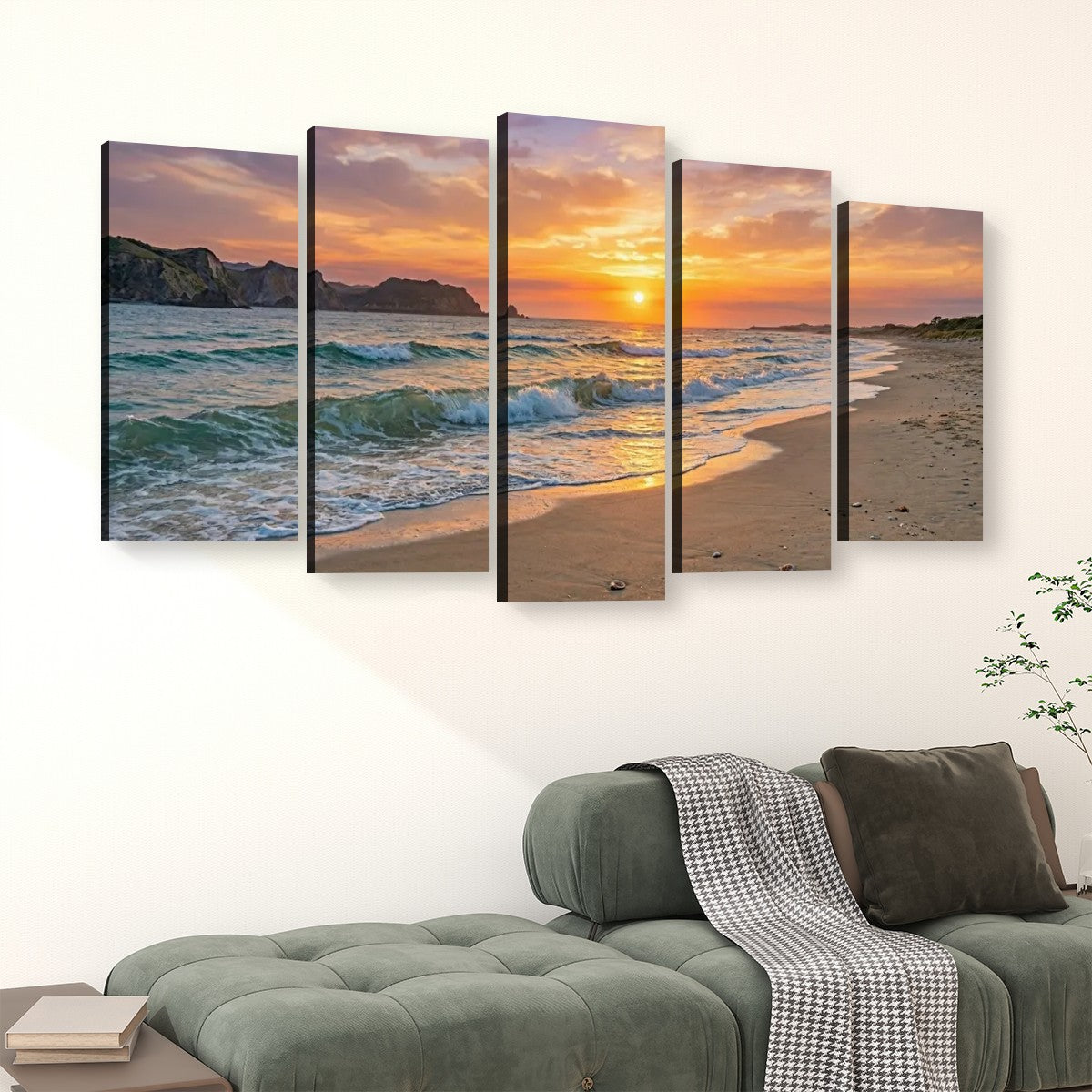 A five-panel canvas wall art set depicting a beach sunset with ocean waves, displayed above a green sofa in a living room setting.