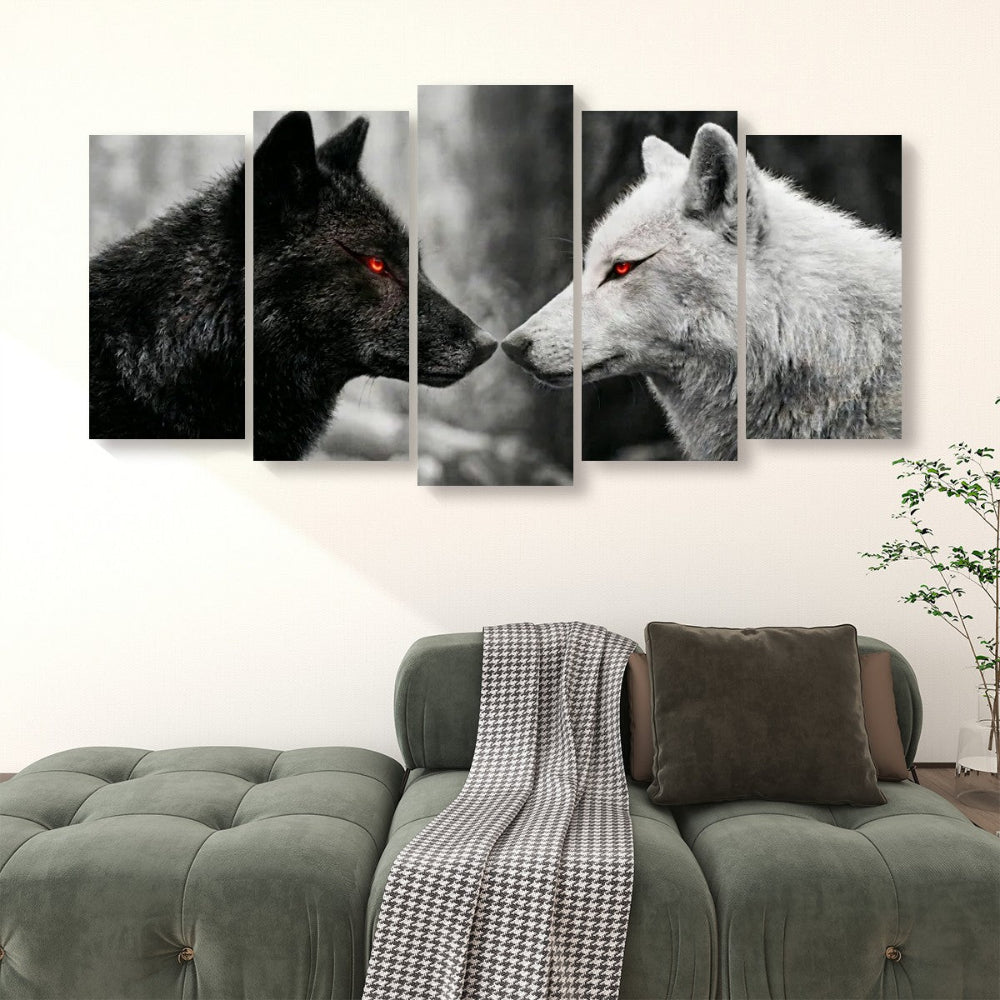 A 4-panel canvas wall art set depicting a black wolf with glowing red eyes facing a white wolf, displayed above a green sofa in a living room setting.