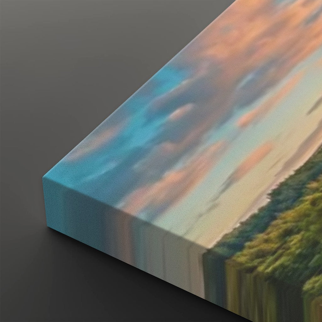 A close-up angled view of a rectangular canvas print resting on a dark gray surface. The artwork shows an abstract landscape-like scene with blue, peach, cream, and green tones.