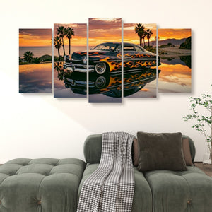 A 4-panel canvas wall art print depicting a Mercury Sled classic car with orange flames on its body, parked in reflective water at sunset with palm trees, displayed above a green sofa in a living room setting.