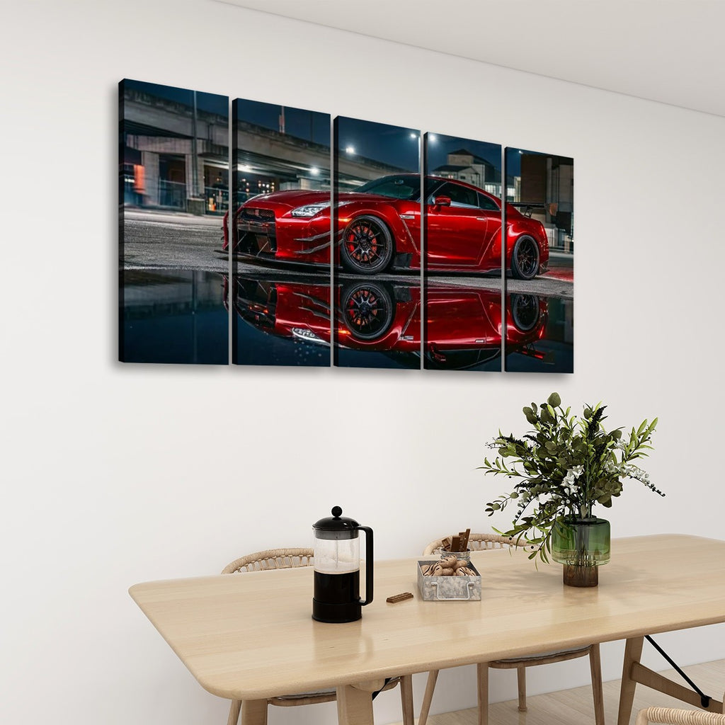 A five-panel canvas wall art set depicting a red  Nissan GTR R35  sports car reflected on wet pavement at night, displayed on a white wall above a light wood dining table with chairs, a coffee press, and a plant.