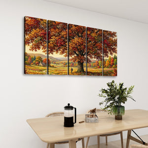 A five-panel canvas wall art set depicting a large autumn tree with colorful fall foliage, displayed on a white wall above a light wood dining table with chairs, a coffee press, and a plant.