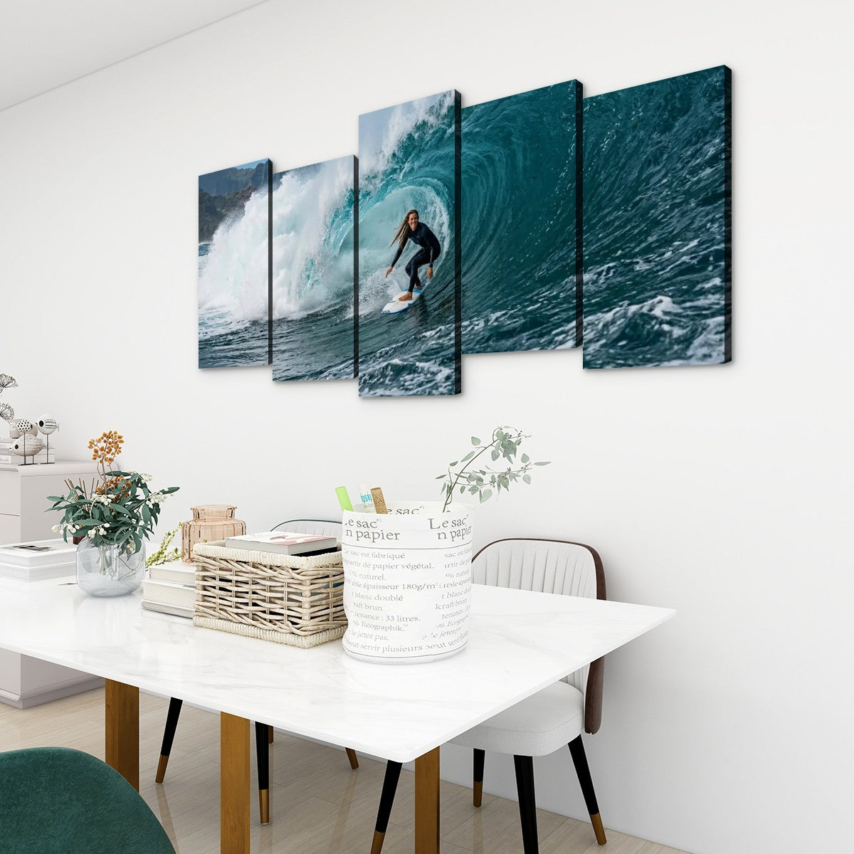 A five-panel canvas wall art set depicting a surfer riding a large blue ocean wave, displayed on a white wall above a dining table in a modern room setting.