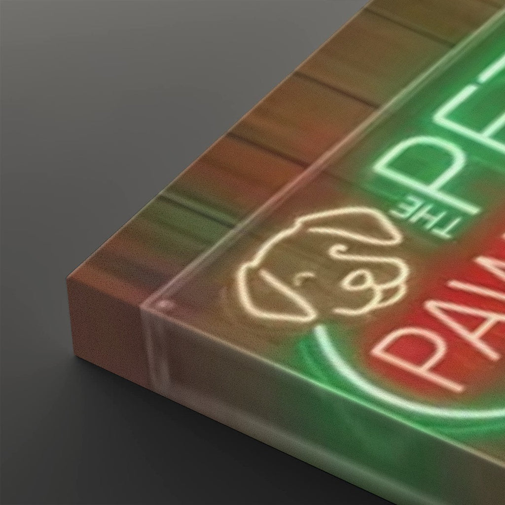 A close-up of a rectangular acrylic or glass wall sign with a warm brown woodgrain edge and glowing neon-style lettering and a dog outline. Visible text includes 'THE PA.