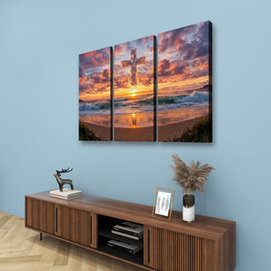 A three-panel canvas wall art set depicting a dramatic sunset over an ocean beach, displayed on a light blue wall above a wooden console table with decorative items.