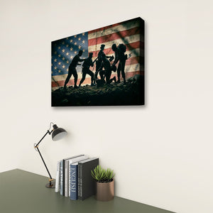 A rectangular wall art print showing silhouetted soldiers carrying a flag across rocky ground, displayed above a desk with a lamp, books, and a small plant in a real interior setting.