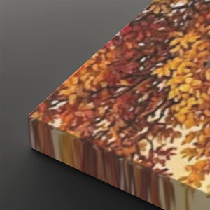 A close-up of a rectangular canvas or print showing an autumn tree with dense red, orange, and yellow leaves, photographed on a dark gray background.