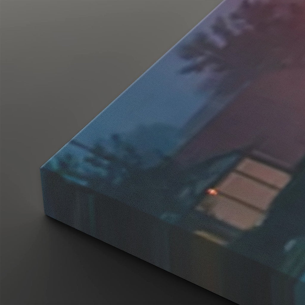 A rectangular canvas or block print with a photographic scene of a building exterior at dusk, shown at an angle on a dark gray background.
