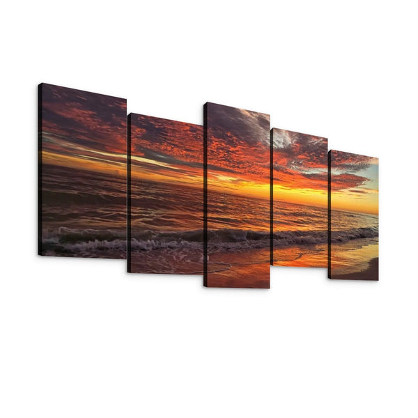 A five-panel canvas wall art set depicting a dramatic sunset over the ocean, with orange and red clouds, dark water, and a bright horizon, shown against a plain white background.