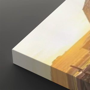 A close-up of a canvas print showing its white wrapped edge and printed scene with warm yellow, orange, and brown tones, set against a dark gray background.