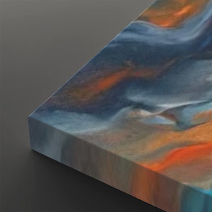 Abstract canvas wall art showing a marbled fluid design with swirling shades of blue, gray, white, and orange, photographed at an angle on a dark gray background.
