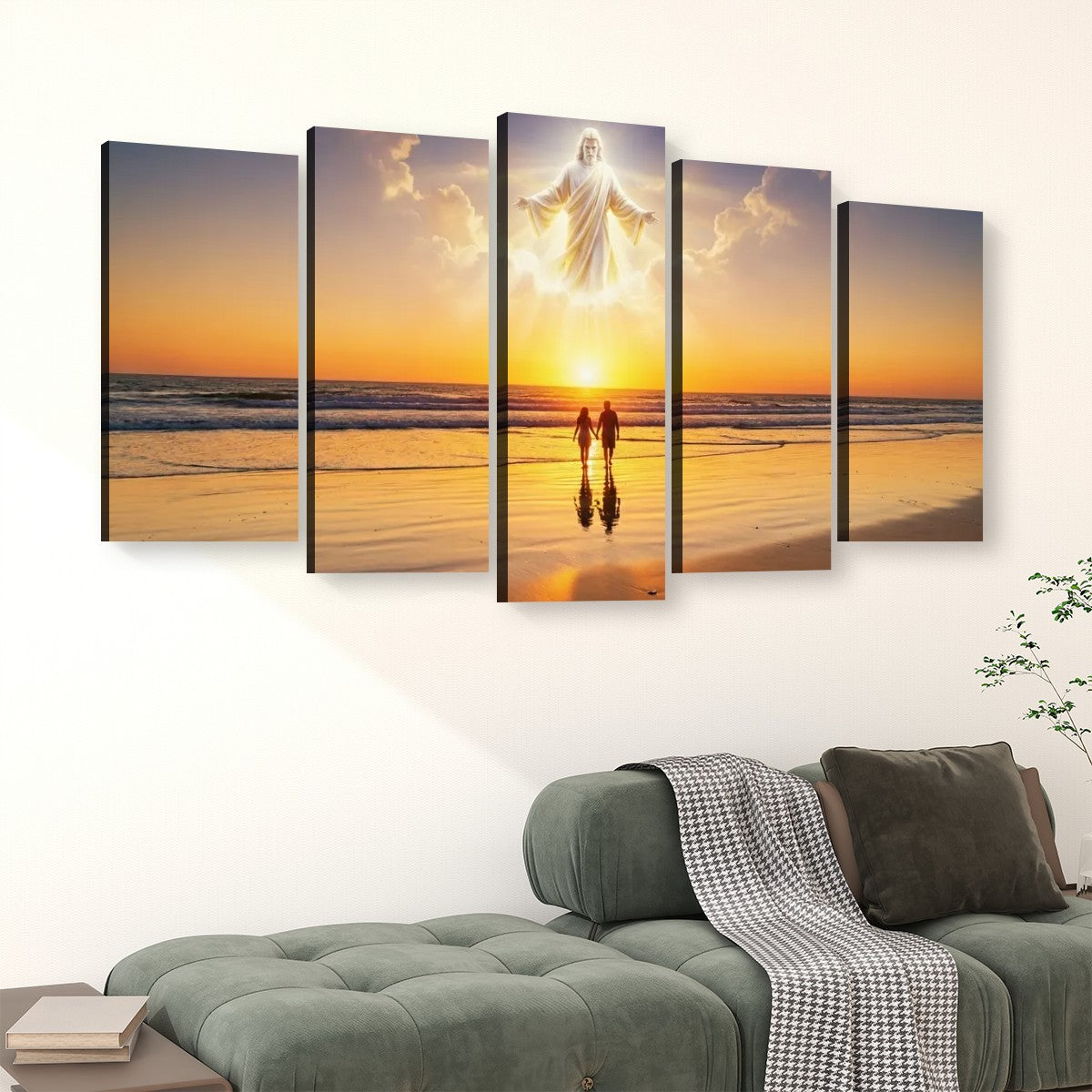 A 5-panel canvas wall art set depicting a beach sunset with a glowing figure above two small figures, displayed above a green sofa in a living room setting.