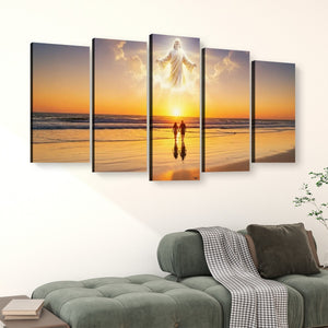 A 5-panel canvas wall art set depicting a beach sunset with a glowing figure above two small figures, displayed above a green sofa in a living room setting.