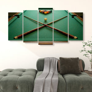 A 4-panel canvas wall art set depicting a green pool table with crossed cues and a ball rack, displayed above a green sofa in a living room setting.