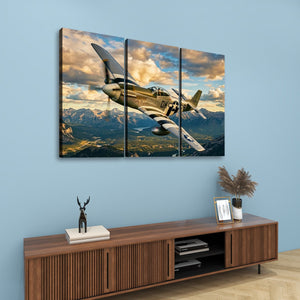A three-panel canvas wall art set depicting a vintage military fighter plane flying over mountains under a dramatic cloudy sky, displayed on a light blue wall above a wooden console table.