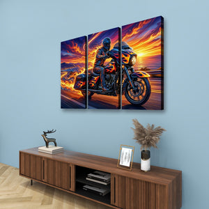 A three-panel canvas wall art set depicting a motorcycle rider on a road at sunset, displayed on a light blue wall above a wooden console table with decorative items.
