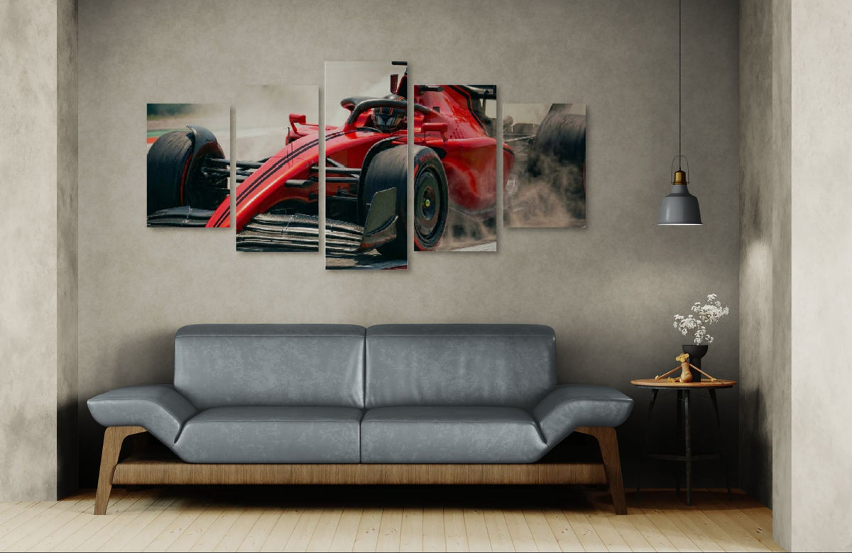 Five-panel wall art of a red race car above a gray sofa in a room.