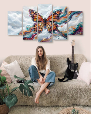 Woman sitting on a couch with a guitar, surrounded by abstract Monarch butterfly paintings.