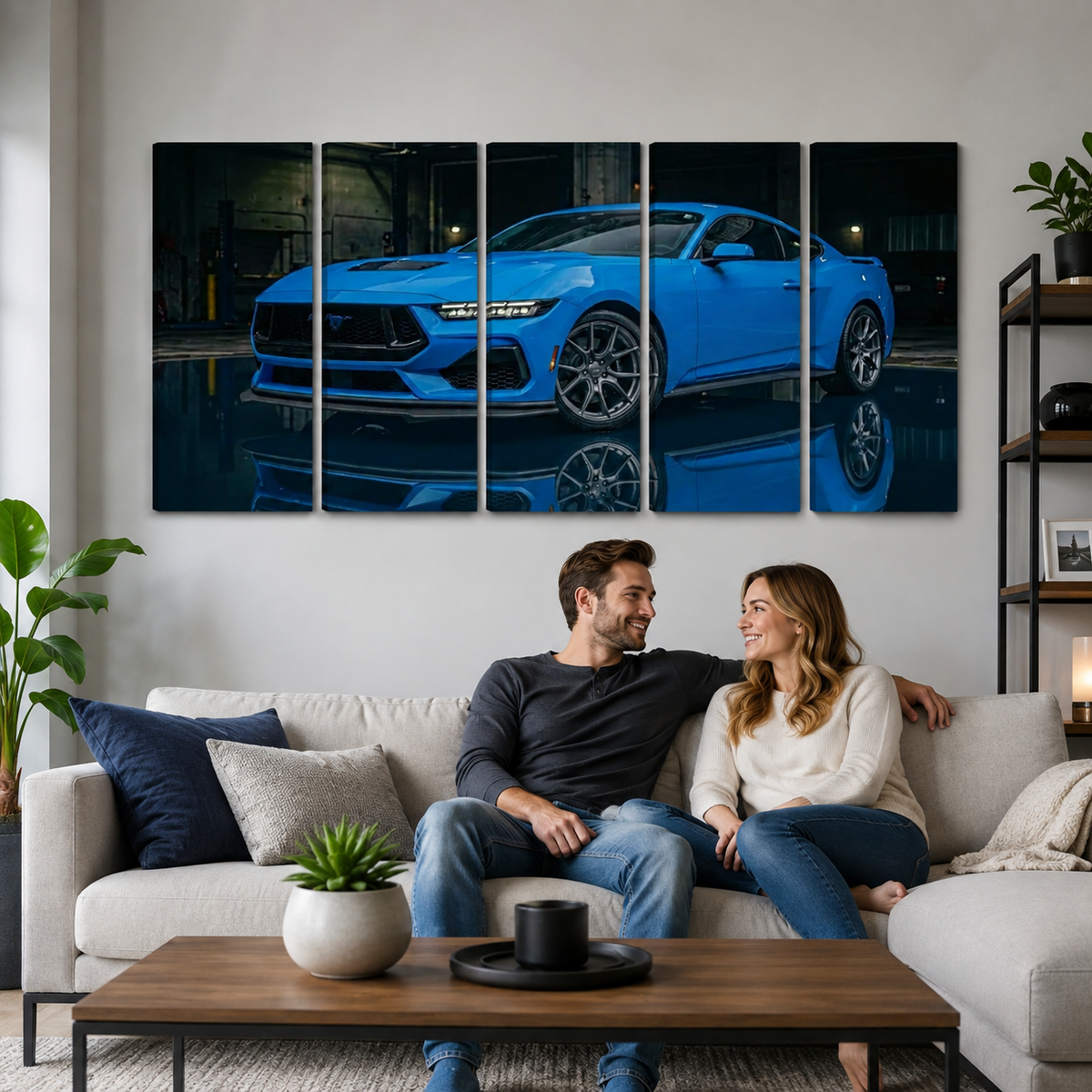 A couple sits on a light gray sofa in a modern living room, looking at a large five-panel canvas wall art print depicting a bright blue sports car on a dark reflective surface.