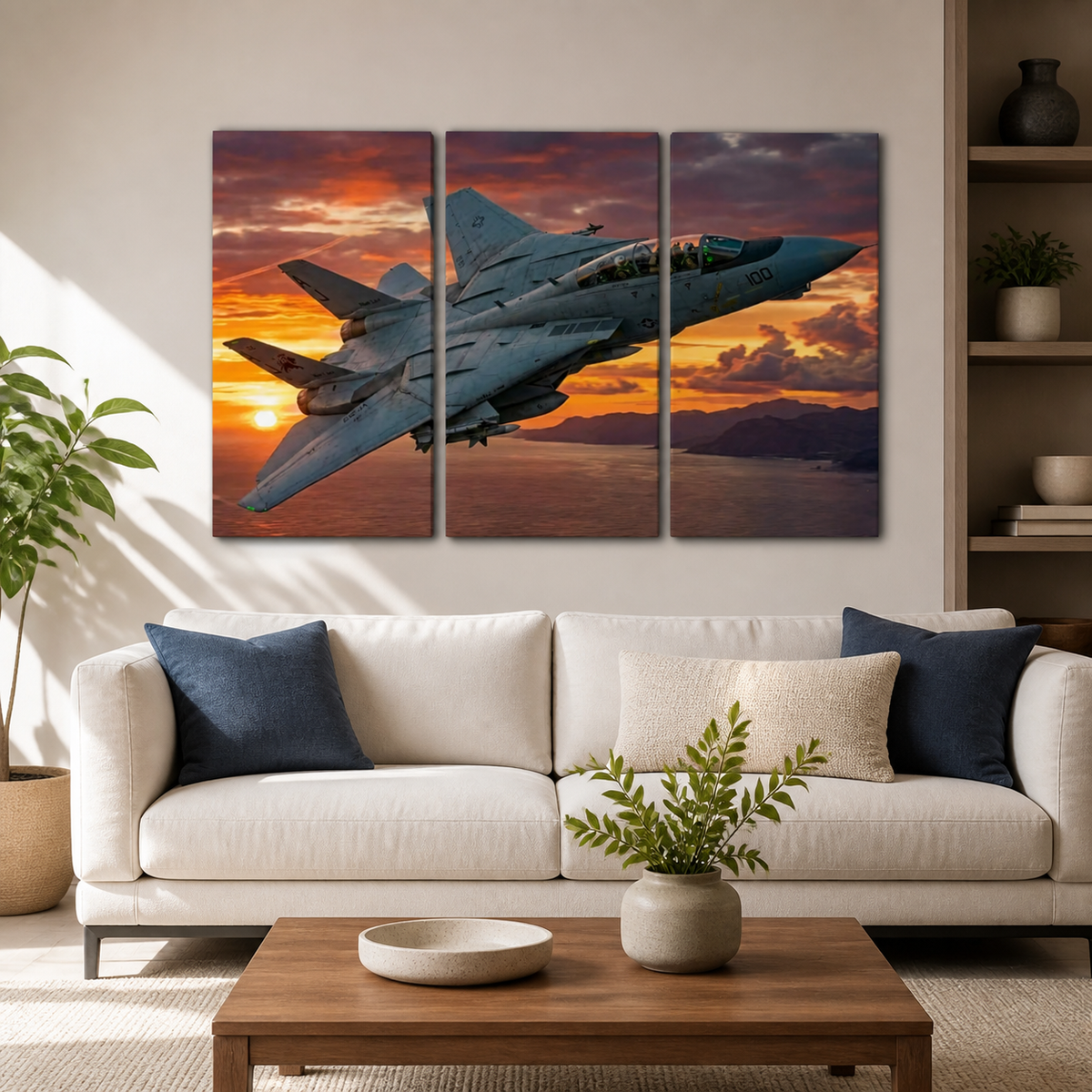 A three-panel canvas wall art set depicting a gray Grumman F-14 fighter jet flying over a sunset landscape, displayed on a beige wall above a modern white sofa in a styled living room.