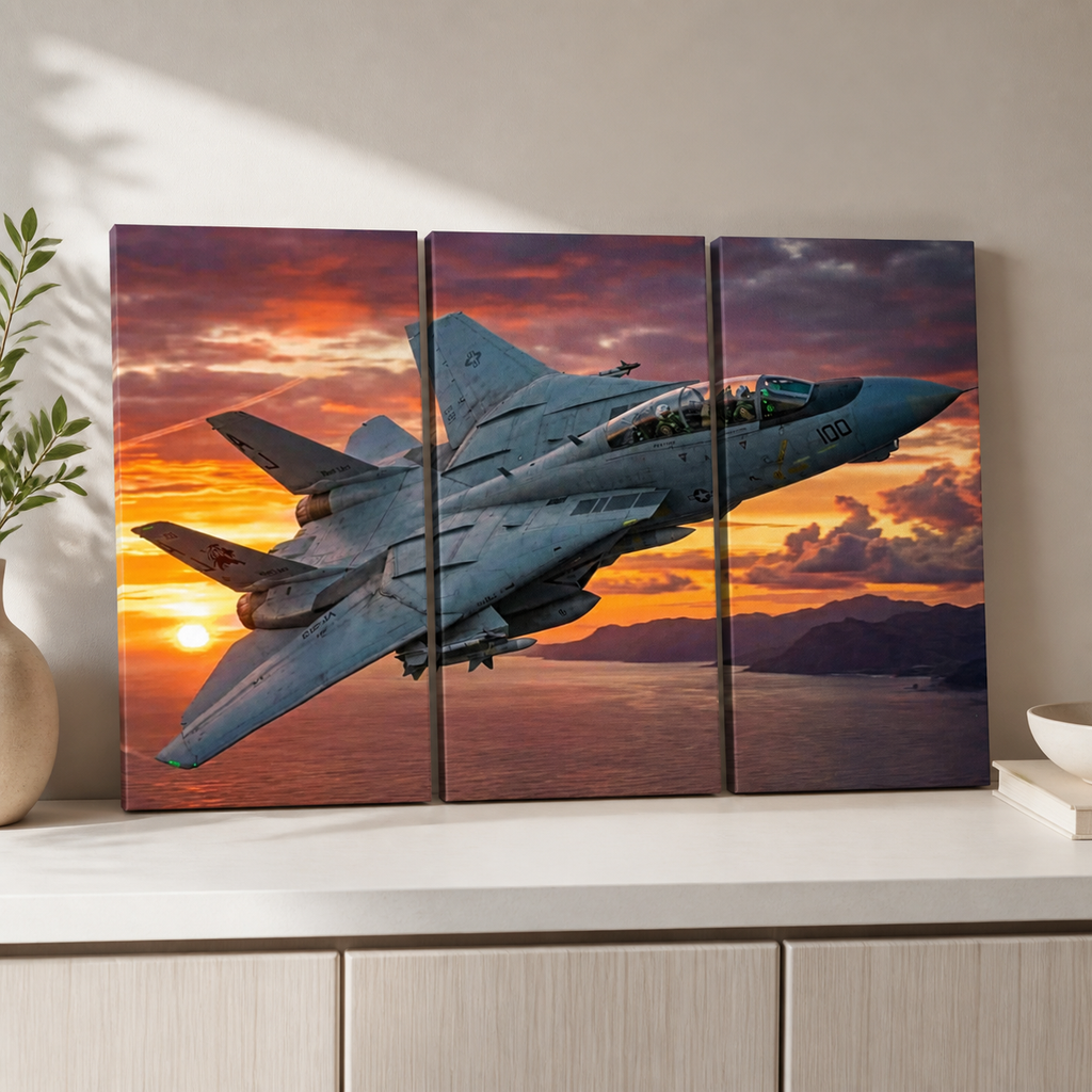 A three-panel canvas wall art set depicting a gray Grumman F-14 military fighter jet flying over a sunset seascape, displayed on a white cabinet against a beige wall.