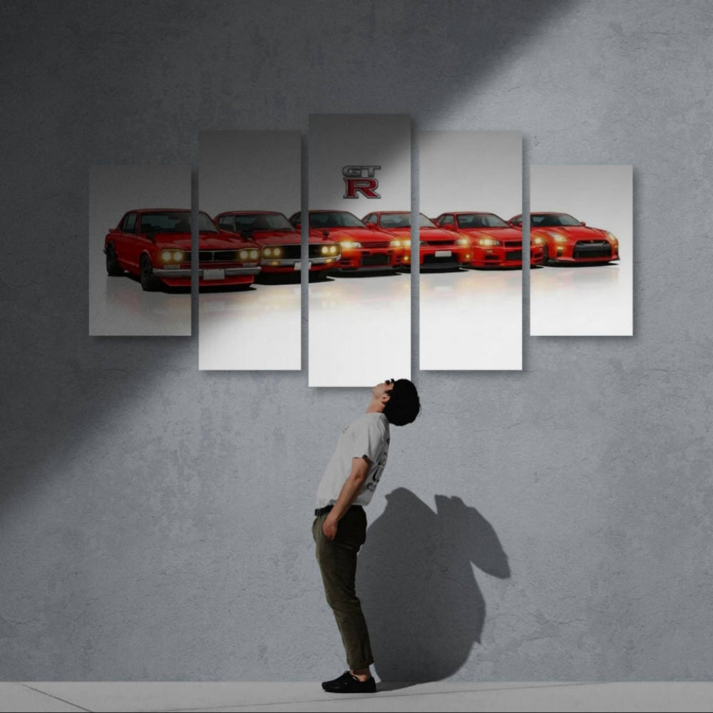 Person looking at a large wall art of red GTR sports cars on a gray wall.