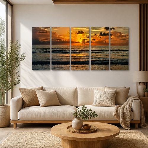 A five-panel canvas wall art set depicting a golden Indian Rocks Beach, Fl sunset over the ocean waves, displayed in a modern living room setting above a beige sofa.