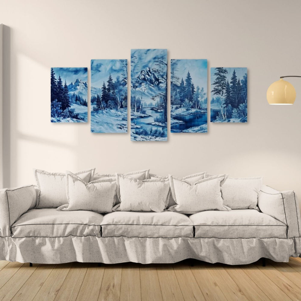 Five blue landscape paintings above a white sofa in a living room.