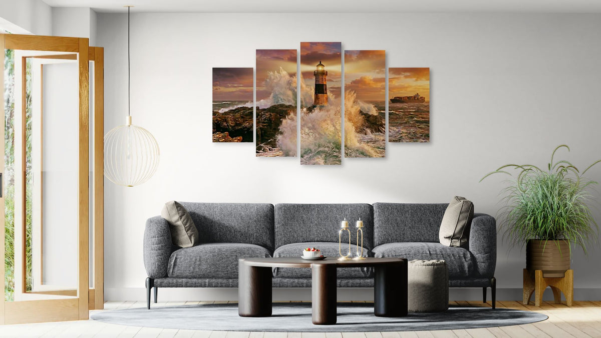Living room with a gray sofa, coffee table, and wall art depicting a lighthouse.