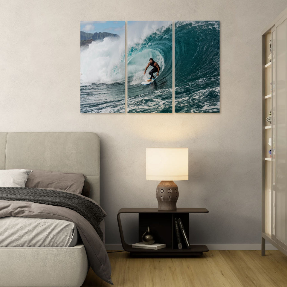 Bedroom with a bed, lamp, and wall art of a surfer in a wave.
