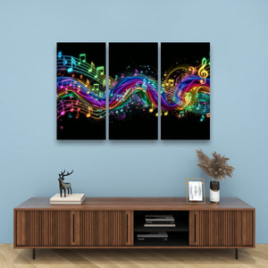 A three-panel canvas wall art set featuring vibrant, glowing rainbow musical notes and treble clefs on a black background, displayed above a wooden console table against a light blue wall.