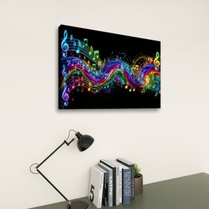 A rectangular wall art print showing a black background with glowing multicolored musical notes and treble clefs, displayed above a desk with books, a small plant, and a black desk lamp in a room setting.